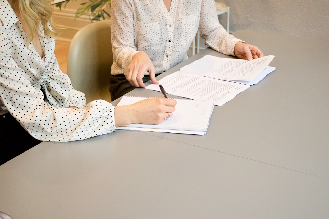 Two people reviewing documents together across a desk