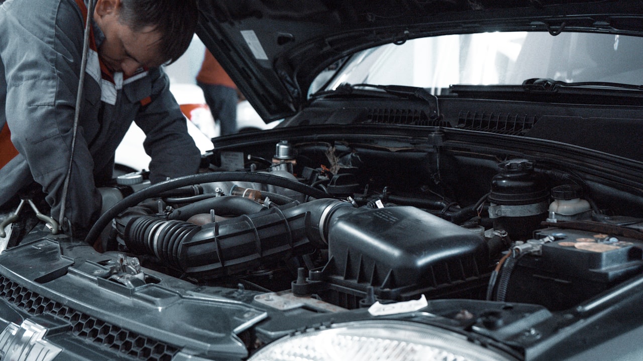 A mechanic working on a car engine in a repair shop